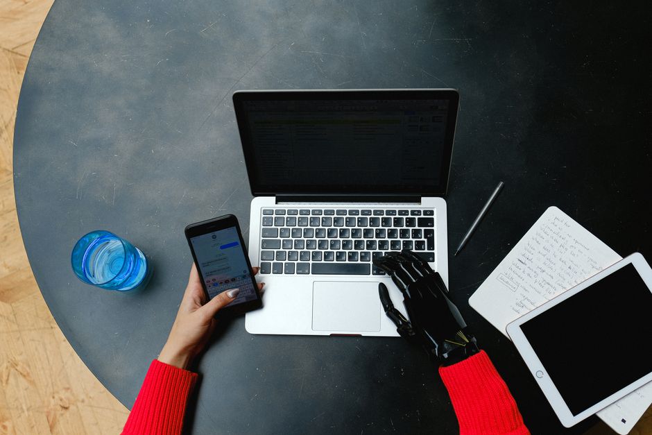 Persona trabajando en un computador portátil con un asistente de inteligencia artificial en pantalla